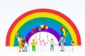 Miniature family: Children holding balloon with rainbow for background. Image use for international children`s day