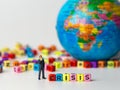 Miniature figure businessman in dark blue suit standing backside of colorful of CRISIS alphabet and globe in the background and th