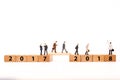 Miniature figure businessman walking on number wooden block across from 2017 to 2018 Royalty Free Stock Photo