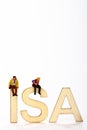 Miniature figure couple sat on wooden ISA letters