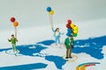 Miniature figure people holding balloons standing on analysis ge