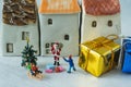 Miniature figure Santa claus giving present to happy children wi