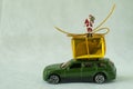 Miniature figure Santa claus standing on big present box on car