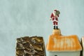 miniature figure Santa claus standing on roof chimney as christmas celebration concept