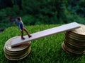 Miniature figure young bussinesman keep trying to get higher income walking at stack of coin at fresh green grass in the morning Royalty Free Stock Photo