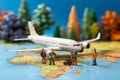 Miniature figures, representing male and female travelers, stand near a world map and airplane Royalty Free Stock Photo