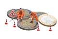 Miniature figures working on a heap of Euro coins. Royalty Free Stock Photo