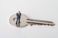 Miniature figurine of a business man on a giant key Royalty Free Stock Photo