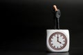 Miniature figurine of a businessman looking his watch Royalty Free Stock Photo