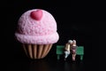 Miniature figurine of a a couple of lovers kissing with a giant dessert