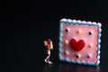 Miniature figurine of a a couple of lovers kissing with a giant dessert