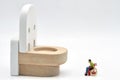 miniature figurine of a disabled man on a wheelchair looking at a huge wc