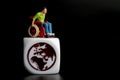 Miniature figurine of a disabled man on a wheelchair with the world symbol