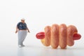 Miniature figurine of a fat man with a giant hot dog sandwich Royalty Free Stock Photo