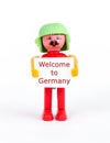 miniature figurine of a man holding paper with text welcome to germany Royalty Free Stock Photo