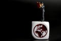 Miniature figurine of a man reading a newspaper upon a world symbol on a black background