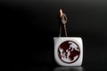 Miniature figurine of a man standing on a dice with the world icon