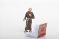 miniature figurine of a monk reading an old religious book Royalty Free Stock Photo