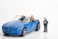 Miniature figurine of a policewoman making a fine to a car driver