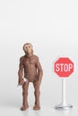 Miniature figurine of a prehistoric hominid with a stop sign