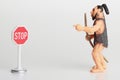 Miniature figurine of a prehistoric hominid with a stop sign Royalty Free Stock Photo