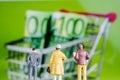 Miniature figurine starring at big defocused euro banknotes in s