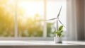 A miniature figurine of a windmill and a green houseplant inside a light modern and minimalist home interior. Trees and sun