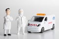 Miniature figurines of a couple of doctors with an ambulance