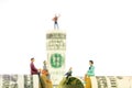 Miniature figurines discussion on the edge of 100 dollar banknote Royalty Free Stock Photo