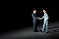 Miniature figurines of handshaking businessmen