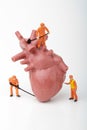 Miniature figurines of men at work with a giant heart