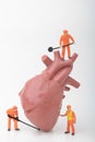 Miniature figurines of men at work with a giant heart