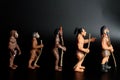 miniature figurines of prehistoric men on line - human evolution concept Royalty Free Stock Photo