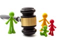 Miniature figurines representing father, mother and children separated by judge gavel concept for family law ruling, joint Royalty Free Stock Photo