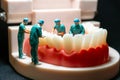 Miniature figurines of surgeons working on a large model of human teeth Royalty Free Stock Photo