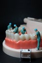 Miniature figurines of surgeons working on a large model of human teeth Royalty Free Stock Photo