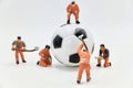 miniature figurines of workers on a soccer balloon