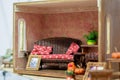 Miniature furnished room. Rattan sofa with red cushions