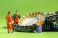 Miniature garbage man sorting beer caps for recycling and reuse to clean the enviroment from trash Royalty Free Stock Photo