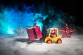 Miniature Gift Box by Forklift Machine on snow ,Determined Image for Christmas Holiday and Happy New Year Gift Celebration concept
