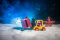 Miniature Gift Box by Forklift Machine on snow ,Determined Image for Christmas Holiday and Happy New Year Gift Celebration concept