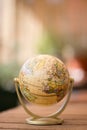 Miniature globe model on a rustic wooden table. Symbol for travelling