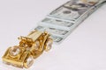 Miniature golden car close up. In the background is a stack of 100 dollar bills Royalty Free Stock Photo
