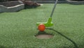 Miniature Golf Putter Tapping Ball into Hole