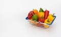 miniature grocery cart filled with colorful peppers. supermarket basket with paprika.