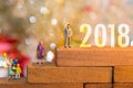 Miniature group happy family holding balloons standing on wooden 2018 with party happy new year Royalty Free Stock Photo