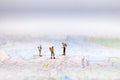 Miniature Group traveler with backpack standing on wold map for travel around the world. Travel Concept,