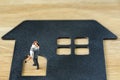Miniature happy couple family figure standing on paper house wit