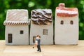 Miniature happy couple family standing with ceramic house as pro Royalty Free Stock Photo