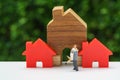 Miniature happy couple family standing with wooden house as prop Royalty Free Stock Photo